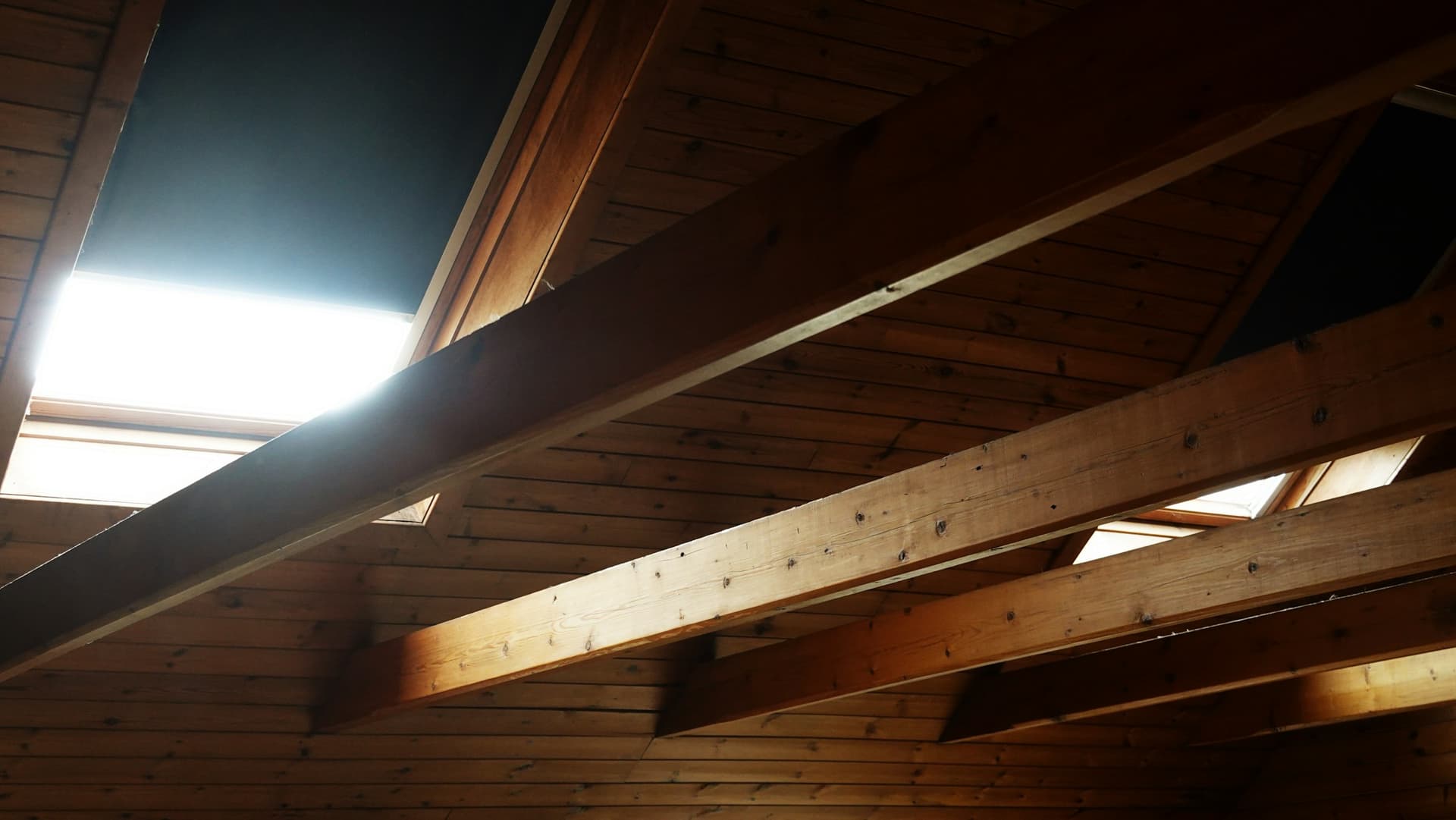 Poutres et chevrons d'une charpente en bois vus depuis l'intérieur des combles